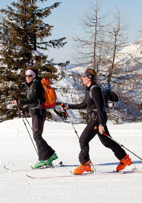 Ski tourers ascending through a snowy alpine mountain landscape