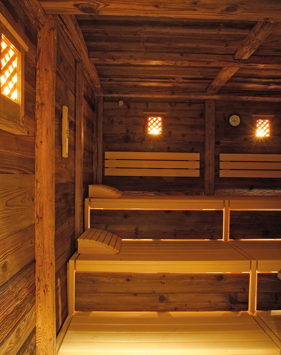 Traditional wooden sauna with warm ambient lighting and multi-level benches