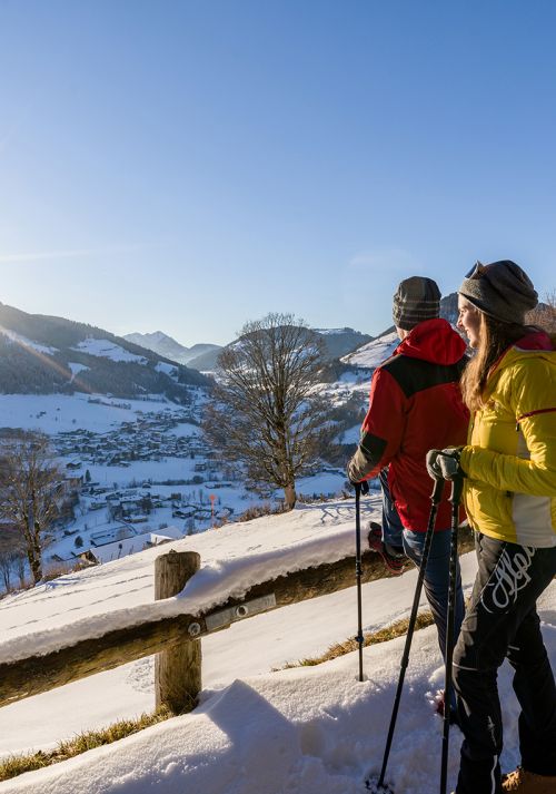 Winter hikers enjoying panoramic views over a snow-covered valley