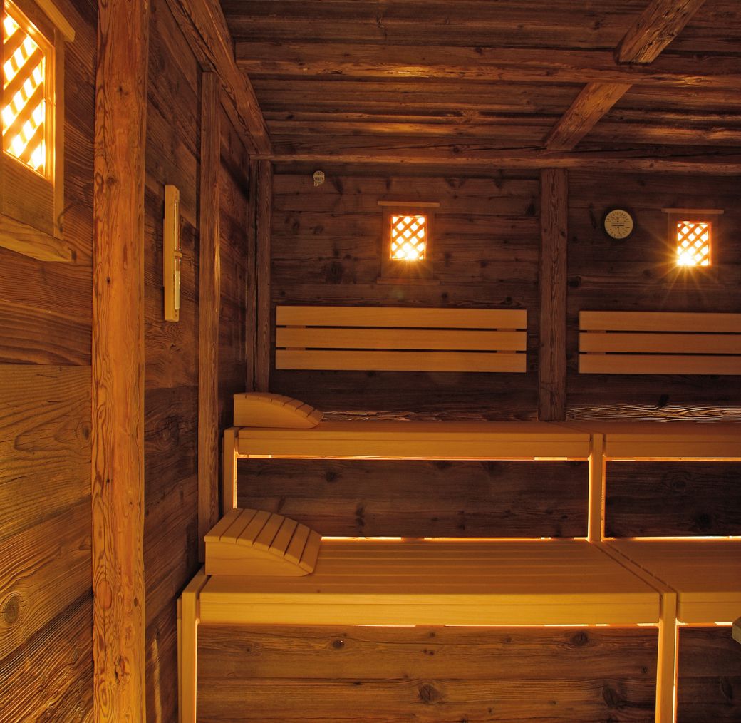 Cozy wooden sauna with warm lighting and multi-level benches